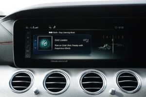 Close-up of a car dashboard featuring digital radio and climate controls.