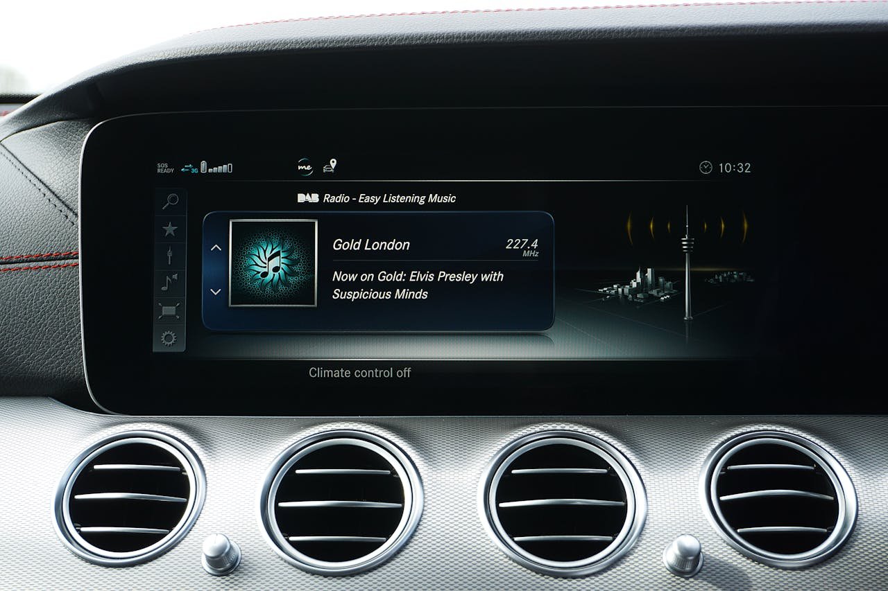 Close-up of a car dashboard featuring digital radio and climate controls.